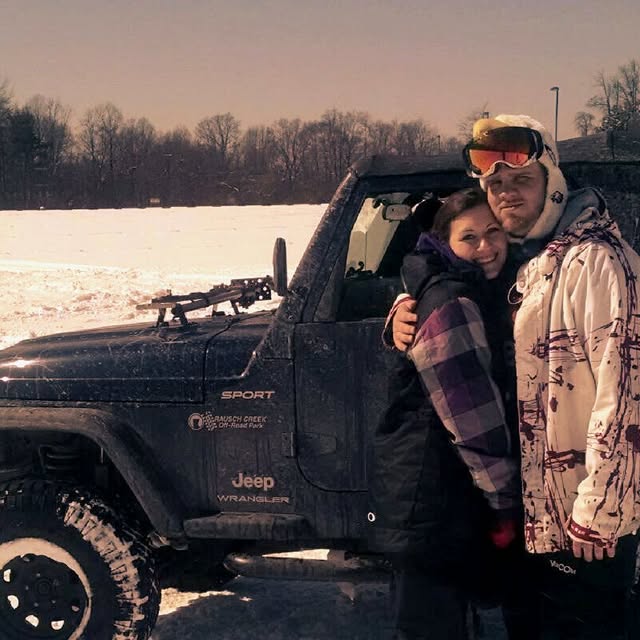 Couple by the Jeep in snow